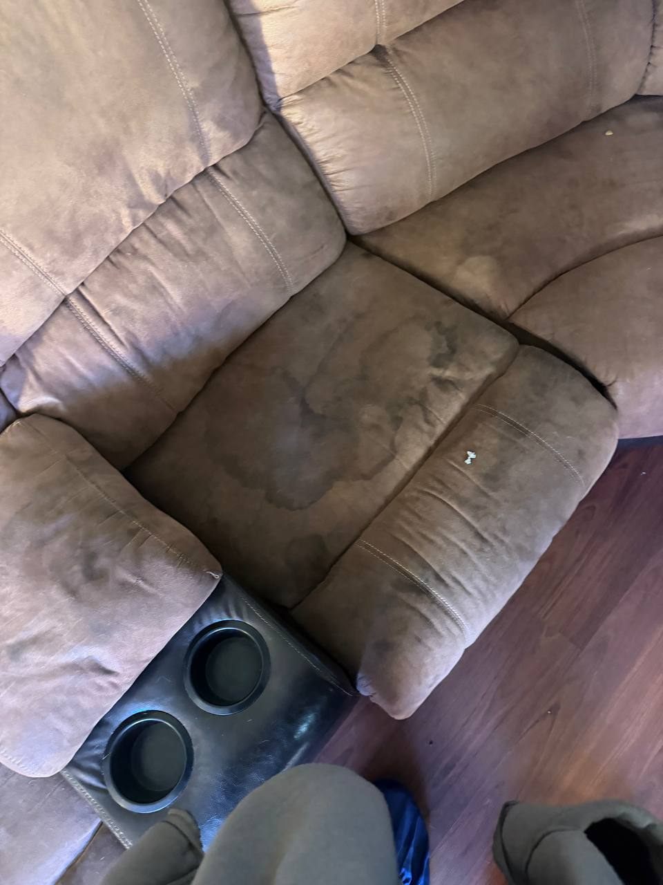 Before upholstery cleaning on a brown sectional seat with visible dark staining